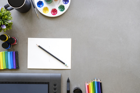 Artist workspace top view a graphic design table with digital mouse pen,sketch book , colour pencil,...