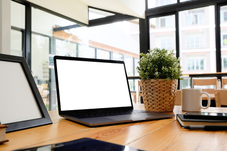 Mockup laptop computer on wooden table in office workspace.の写真素材