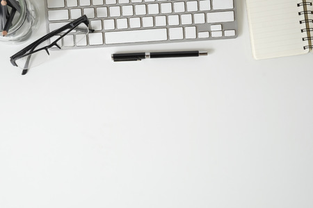 Topview office desk keyboard computer and glasses with notebook paper on white table with copy space.の写真素材