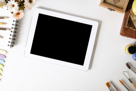 Mockup tablet on artist workspace and office creative supplies on top view table.の写真素材