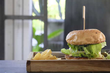 Closeup homemade Burger and French fries on wood plate.の写真素材