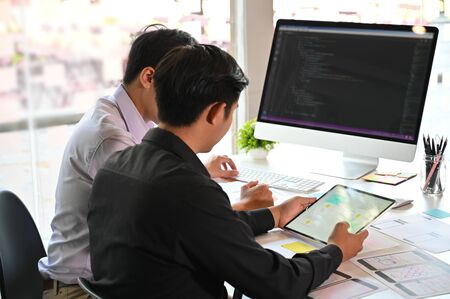 A two male programer working with laptop and coding on computer.の写真素材