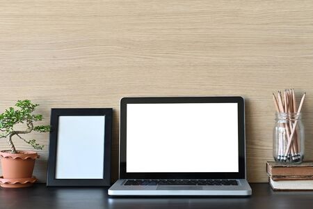 Workspace mockup laptop computer and office supply on office desk and wooden wall.の写真素材