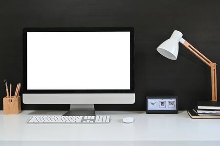 Workspace blank screen desktop computer, Mockup computer, lamp and home office accessories on white desk.の写真素材