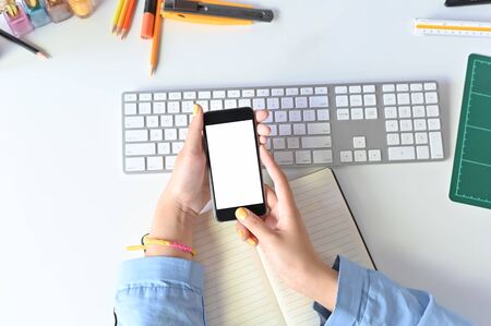 Mockup smartphone on woman hands using on office workspace.の写真素材
