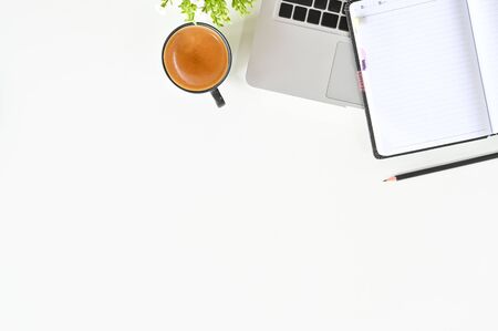 Office desk with laptop, coffee, notebook and pencil on white table top view.の写真素材