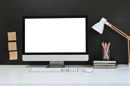 Workspace blank screen desktop computer, Mockup computer, lamp and home office accessories on white desk.の写真素材