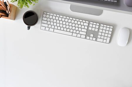 Office desk computer, keyboard, mouse and coffee on white table.の写真素材