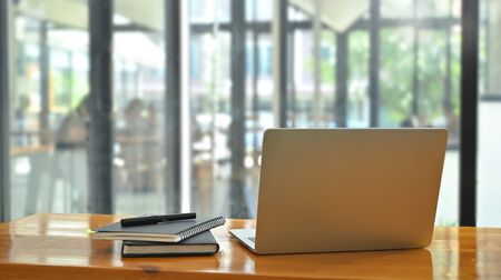 Simple workspace table with laptop and notebook paper.の写真素材