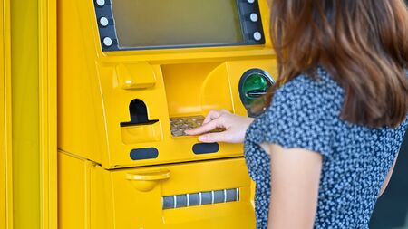 Close-up young woman touching on atm in a shopping mall.の写真素材