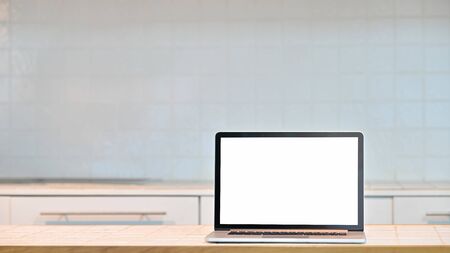 Laptop computer with empty screen on counter bar in kitchen room.の写真素材