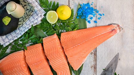 Top view Salmon filet steak on wood table with lemon, wasabi and parsley.の写真素材