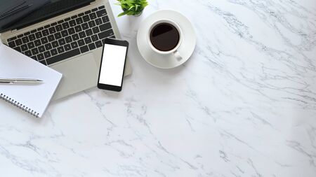 Stylized marble office desk flat lay laptop, pen, notebook, coffee with plant and mockup phone on top view copy space.の写真素材