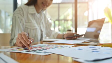 Close-up creative graphic designer with her working on colour selection on paper colour.の写真素材