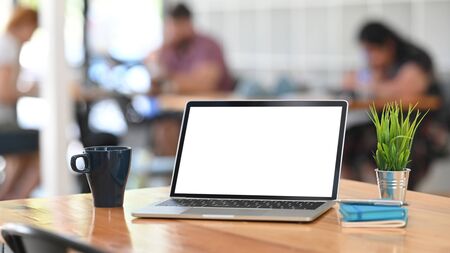 Laptop computer, coffee, notebook and pen on wooden table on co working background.の写真素材