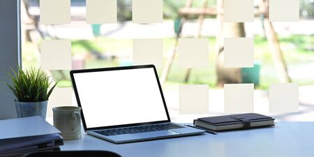 Workspace desk with Mockup Laptop with blank screen and coffee mug, notebook with document paper in office table.の写真素材