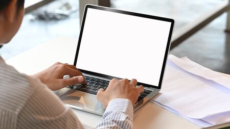 Cropped shot man typing mockup laptop computer with blank screen.の写真素材