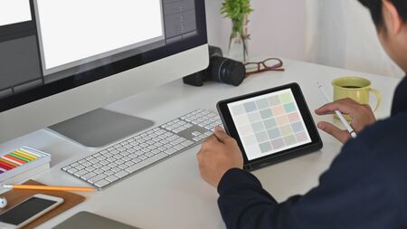 Young creative man giving concentrate on his tablet.の写真素材