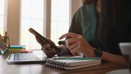 Cropped shot photo of woman using smartphone.