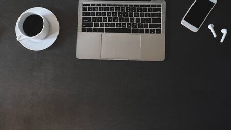 Top view flat lay office desk leather with laptop, mobile phone, earphones with coffee.の写真素材