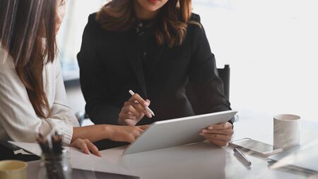 Cropped shot of confidence woman while consulting to young businesswoman next to her.の写真素材