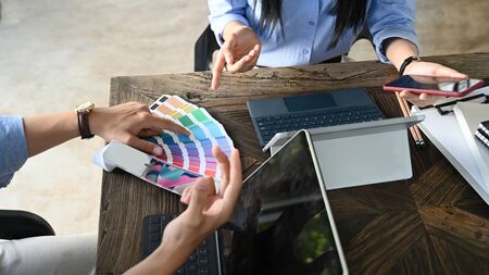 Cropped image of business development team working/meeting at the modern wooden table with white...