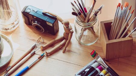 Photo of artist working table with accessories. Graphic designer desk essentials top view with wooden texture background. Set of artist accessories collection.の写真素材