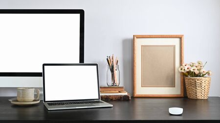 An Orderly workplace with laptop and pc computer and accessories putting together on it.の写真素材