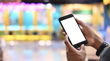 Businessman's hands holding white blank screen smartphone with blurred background.の写真素材