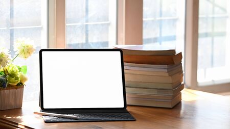 Education technology concept, Mockup digital tablet empty screen and books on wooden table.の写真素材