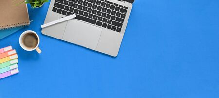 Simple Top view table - Creative flat lay Blue working desk with office equipment putting on it. Laptop, Coffee cup, Marker pens, Potted plant and Notebook. Modern/Orderly workplace.の写真素材