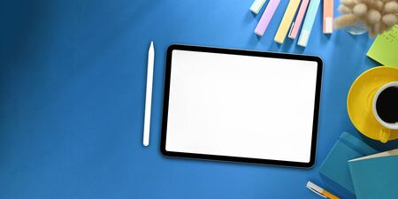 Top view image of white blanks screen computer tablet with stylus pen putting on colorful working...