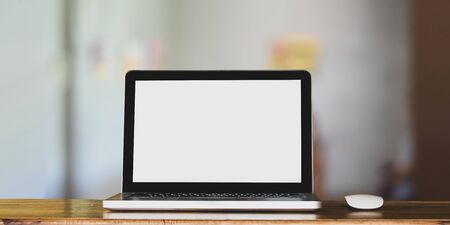 Laptop with wireless mouse putting on wooden counter bar for advertisement over comfortable sitting...