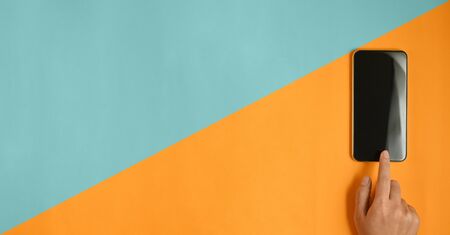 Copy space hands is using a black blank screen smartphone at a two-tone workspace.の写真素材