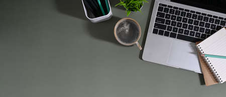 A man is using a computer tablet while sitting on a camping chair over the grass field.の写真素材