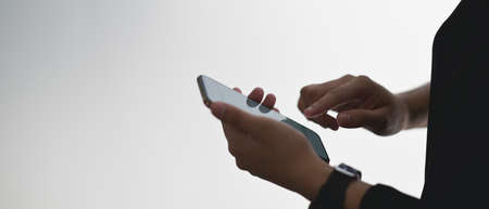 A beautiful woman is using a computer tablet with a white blank screen while sitting at the wooden counter bar.の写真素材