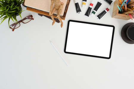 Modern work space, laptop with white screen, coffee cup and note book on white table.の写真素材