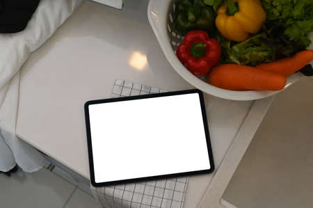 Modern work space, laptop with white screen, coffee cup and note book on white table.の写真素材
