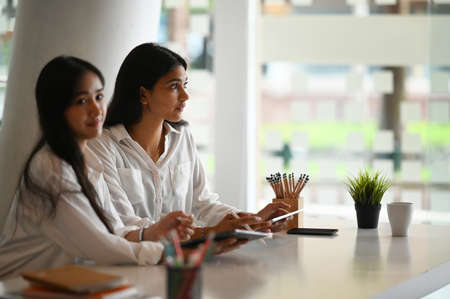 Attractive businesswomen working together with laptop in modern office.の写真素材