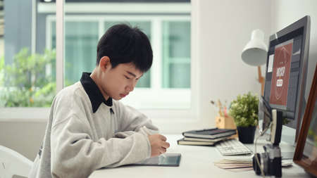Young graphic designer woman using digital graphic tablet while working in modern office.の写真素材