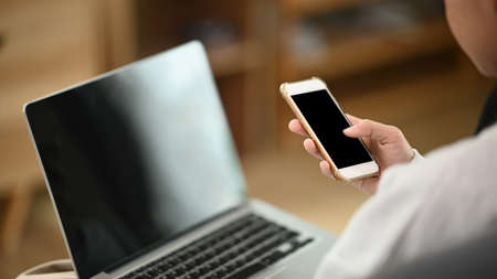 A professional businesswoman using smartphone in her office room.