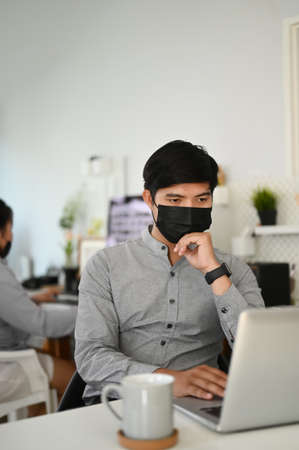 Two office worker are working and wearing mask for protect Covid19 or corona virus disease.