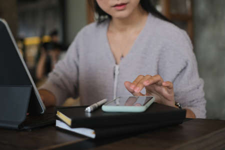 Portrait of female office worker concentrating on her work with computer in modern office.の写真素材