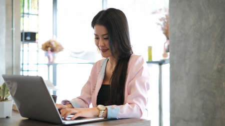 Shot of an attractive businesswoman working on laptop in her modern workstation.