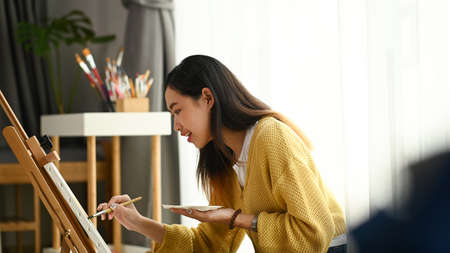 A beautiful female artist is painting with watercolour paints.Creativity and imagination concept.