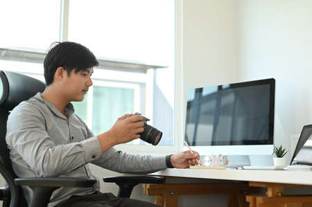 Cropped shot of a young designer sitting at graphic studio in front of computer while working online.の写真素材