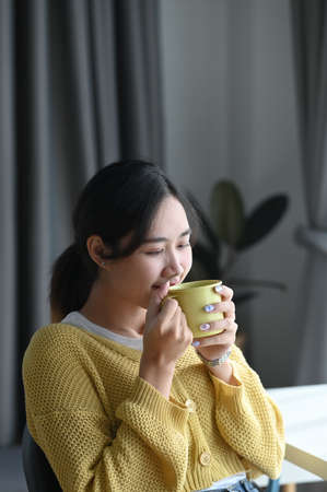 Portrait of a woman hands holding cup of hot beverage and smilingの写真素材