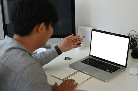 Cropped shot of man office worker working with computer laptop at his workspace in office.の写真素材