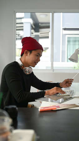 Portrait of graphic designer or photographer is using digitizer and colour sample in his office.の写真素材