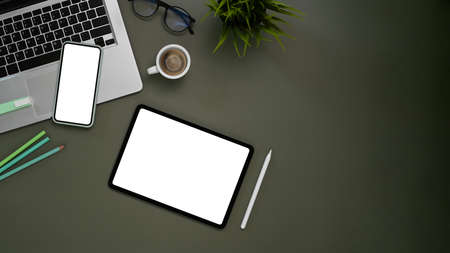 Cropped shot of businesswoman hand typing on blank screen mobile phone at her workspace.の写真素材